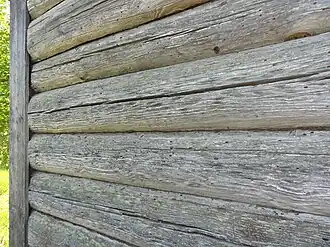 Северная стена дома из брёвен по прошествии 70 лет с постройки