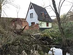 Вид на ГЭС сзади-справа. Внизу видна бетонная труба, через которую вода поступала к генератору. Также слева от здания видны развалины старого здания постройки 1949 года, которые от основной части постройки небыли восстановлены в 1998 году.