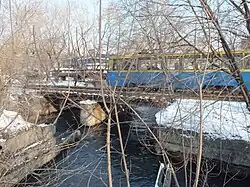 Владивостокский трамвай на мосту через реку Объяснения. На фото слева — Ленинский район (правый берег), на фото справа — Первомайский район (левый берег)