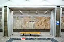 Скамейка и название станции на путевой стене