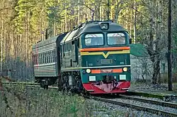 Тепловоз М62 с вагоном у низкой платформы.