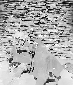 Пожилая женщина с веретеном у детской люльки в ауле Хуландой