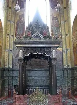 Сень над местом ранения Александра II. Под ней сохранена часть мостовой и ограждение набережной, обагрённые кровью царя. Прямо над ней колокольня с большим золотым куполом