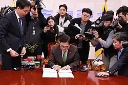 Спикер Национального собрания У Вон Сик подписывает резолюцию об импичменте перед представителями СМИ после успешного второго голосования по импичменту 14 декабря 2024 года