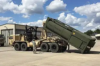 Солдаты из 240-й роты квартирмейстерской поддержки грузят с помощью мультилифта цистерну с водой, известную как Hippo («Бегемот»), на HEMTT M1120 LHS в Баумхольдере.