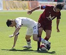 В борьбе за мяч Евгений Алдонин (22) и Алехандро Домингес (10)