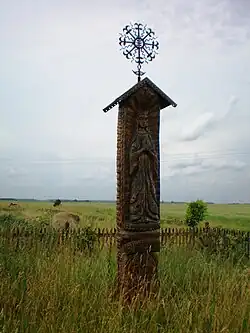 Стогастульпис с декорированным железным крестом с цветочными мотивами. Село Ангирас, северо-запад города Йосвайняй.