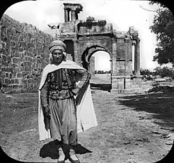 Житель Тебессы в бурнусе, на заднем плане — арка Каракаллы, кон. XIX-нач. XX в.