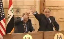 Джордж Буш уворачивается от ботинка, пущенного в него Мунтазаром аль-Зейди. Справа премьер-министр Ирака Нури Аль-Малики.