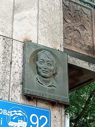 Мемориальная доска на доме, где жил Санжар Оразулы Жандос (улица Зенкова,92), с его портретом