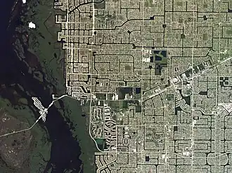 Вид на Кейп-Корал из космоса. Тёмно-синие «дорожки» и участки — водные каналы.