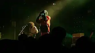 Итан Айвз и Уилл Толедо (в костюме) выступают на концерте, 2022 год