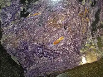 Отполированный чароитовый штуф в музее Геологии СО РАН.
Крупные жёлтые кристаллы, скорее всего, тинаксит