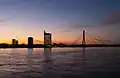 Вантовый мост через Даугаву, на заднем плане — здание Saules akmens