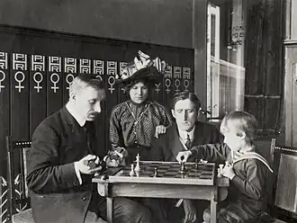 Схелфхаут играет с сыном Ф. Маршалла. За партией наблюдают Маршалл с супругой (Амстердам, 1911)