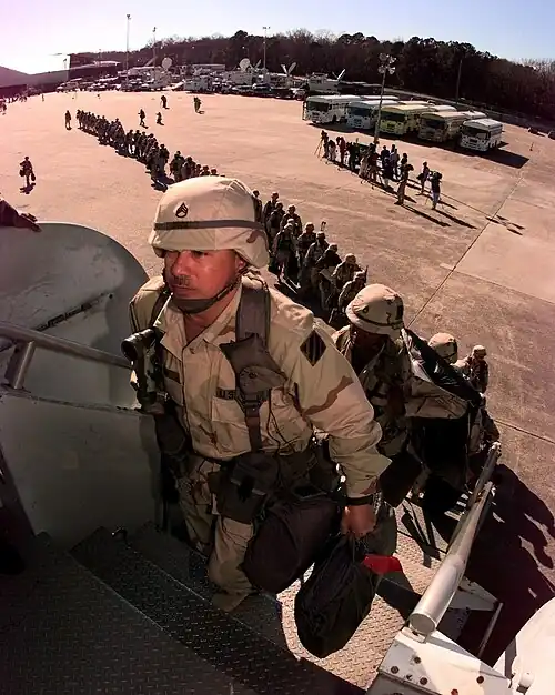 Штаб-сержант Гарсия из 3-го батальона 69-го бронетанкового полка 3-го пехотного полка, Форт-Стюарт, штат Джорджия, возглавляет длинную шеренгу солдат, садясь на чартерный самолет на аэродроме Hunter Army Air Field, штат Джорджия, для отправки в регион Персидского залива 18 февраля 1998 года. Солдаты отправляются на театр военных действий в Юго-Западной Азии в поддержку операции Southern Watch. Southern Watch — это обеспечение соблюдения бесполетной зоны над Южным Ираком, осуществляемое США и коалицией.