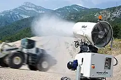 Туманообразующая пушка направлена на трактор, работающий в карьере