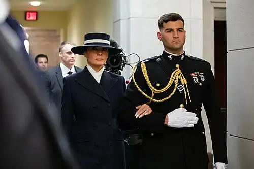 Первая леди США Мелания Трамп в сопровождении офицера корпуса морской пехоты США направляется в ротонду Капитолия