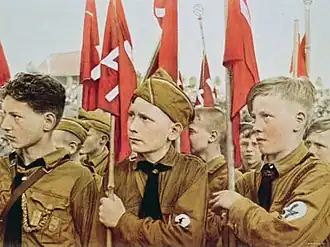 Пропагандистское фото юных бойцов Гитлерюгенда ручной раскраски. Мальчики одеты в коричневые рубашки с простой руной Зиг (символ организации Юнгфольк), 1933