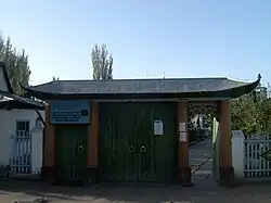 Ворота Дунганской мечети в Караколе, Кыргызстан. Верхний текст на знаке представляет собой частично уйгурский перевод кыргызского названия мечети на уйгурский арабский алфавит: Исик-кёль областтык Каракол шариндаги Ибрагим Хаджи атиндаги борбордук масджид. Нижний текст — киргизский язык в кириллице: Ысык-Көл областтык Каракол Шаарындагы Ибрагим Ажы атындагы борбордук мечит —Центральная мечеть имени Ибрагима Хаджи в городе Каракол, область Иссык-Куля