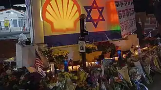 Цветы, свечи, флаги и надписи мелом на месте смертельного ранения Пола Кесслера