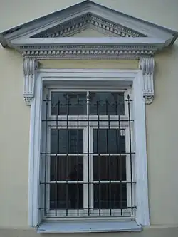 Окно с треугольным фронтоном на кронштейнах