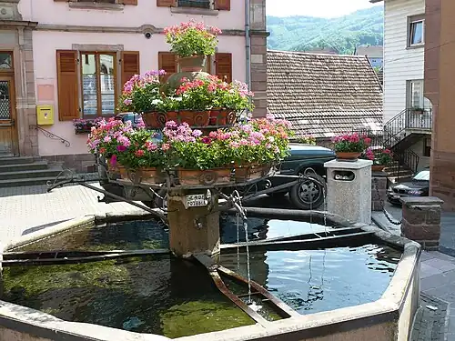 Старый восьмиугольный фонтан рядом с церковью