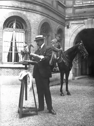 Жорж Малиссар делает макет статуи маршала Фоша верхом (позади него)