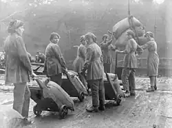 Женщины перевозят мешки с помощью тележек во время Первой мировой войны.