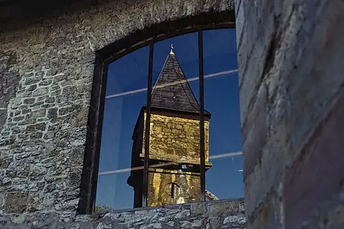 Башня переднего замка отражена в окне главного замка.