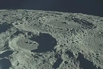 Снимок с борта Аполлона-17, сделан над сателлитным кратером Орлов Y. Кратер Орлов немного левее центра снимка, вверху справа – кратер Левенгук.