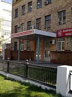 Проходная комбината, справа — вывеска розничного магазина при заводе