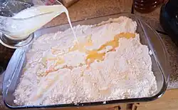 Растопленное масло заливается на смесь для торта перед выпечкой. В некоторых рецептах вместо этого используются твердые кусочки масла.