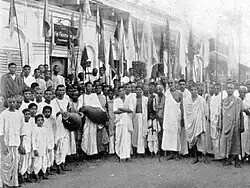 A group of India people with drums and flags in a semicircle