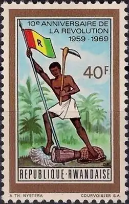 Посвященная десятилетнему юбилею революции руандийская марка 1969 года, изображающая свободного по революции рабочего с кайло и флагом