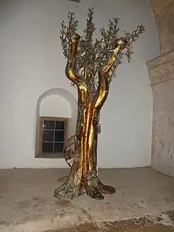 Символическое оливковое дерево с колосьями у корня, обвитое виноградной лозой. Вероятно отсылка к словам ап. Павла (Рим. 11:17-24)