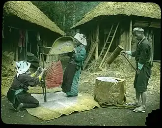 Женщины с веялкой и веером, мужчина с деревянным молотом