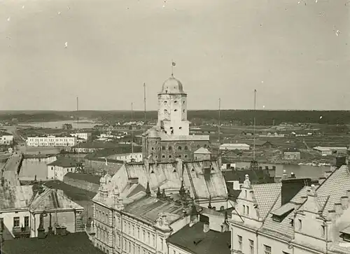В правом нижнем углу видна часть четвёртого этажа и кровли с фронтонами и шахматным рисунком (фото 1910-х годов)